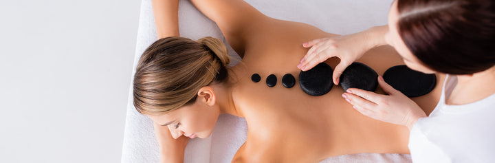 Woman relaxing during a hot stone massage at Pure Beauty & Wellness Spa