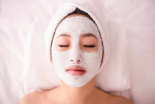 teen girl with towel on her head wearing a face mask with her eyes closed